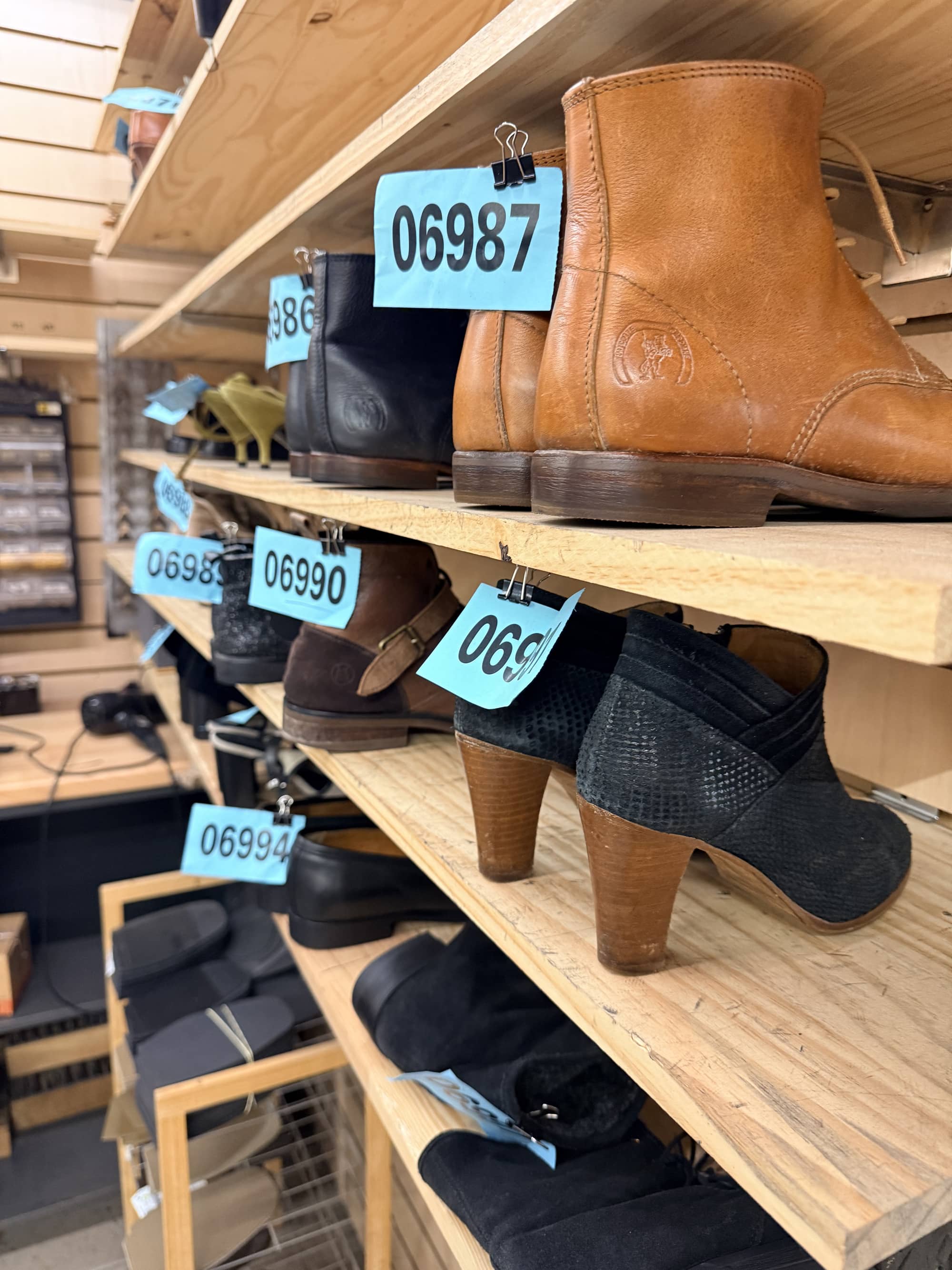 Étagères de chaussures en attente de réparation, atelier de cordonnerie