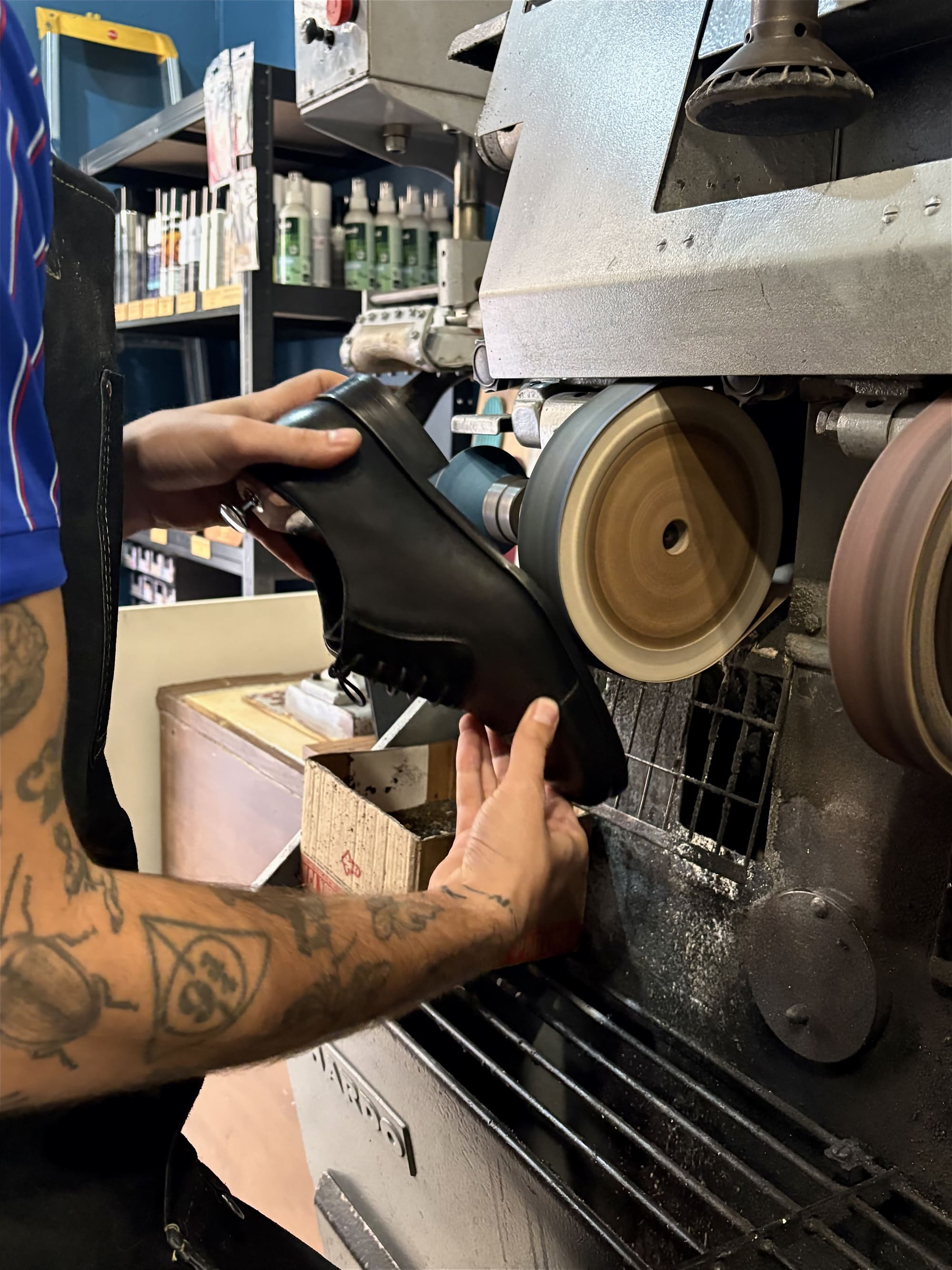 Artisan polissant une chaussure sur une machine à meules en boutique