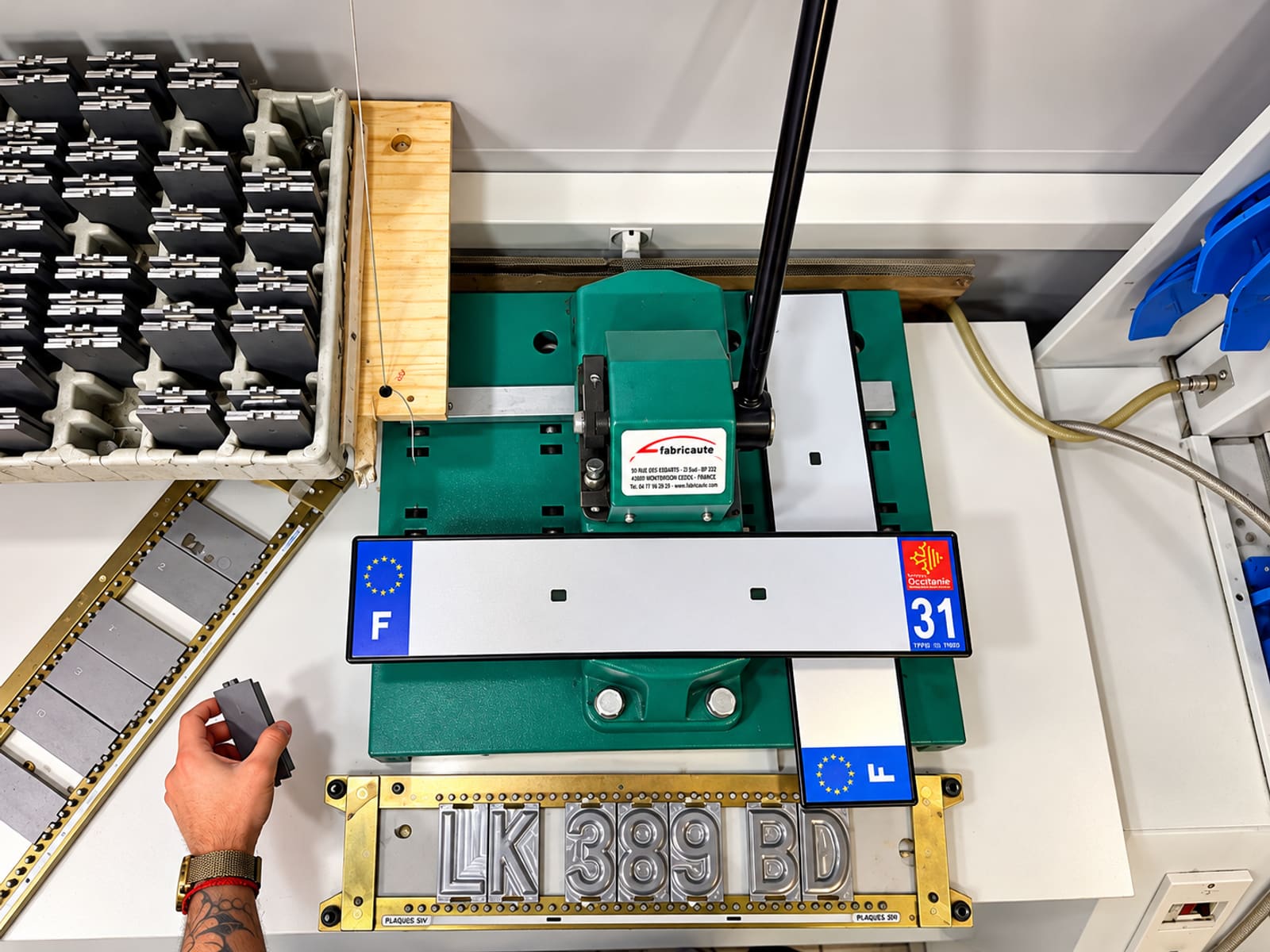Machine de fabrication de plaques d'immatriculation en cours de frappe